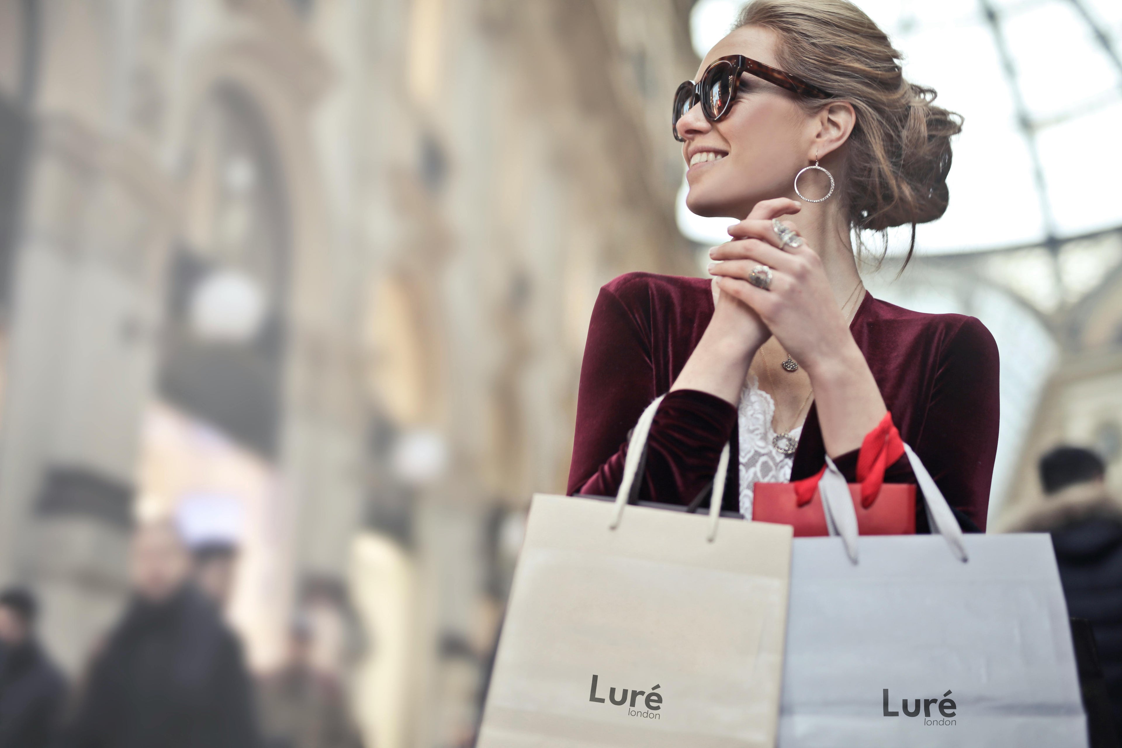 Woman holding shopping bags with 'Lure' brand in an urban setting